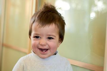 Closeup indoor portrait of a baby boy with naughty hair. The various emotions of a child are...