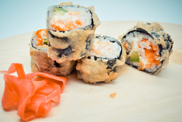 hot homemade roll tempura shrimp and avocado lying next to the ginger, the concept of home Asian-inspired dinner.