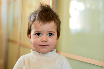 Closeup indoor portrait of a baby boy with naughty hair. The various emotions of a child are...