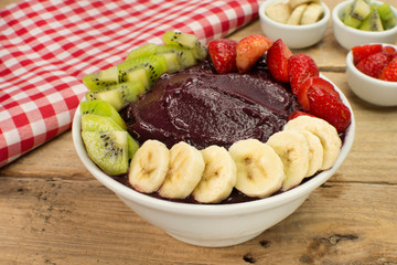 Brazilian acai and fruits in wood background
