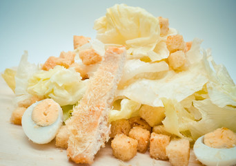 fresh homemade Caesar salad with quail eggs and Parmesan cheese grated on a fine grater.