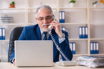 Aged male employee working in the office 