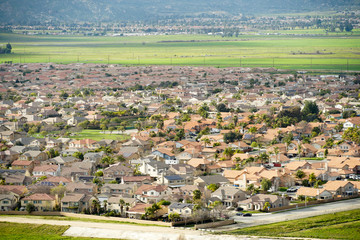 Obraz premium Aerial view suburban neighborhood with identical wealthy villas next to each otherwith mountain behind. California, USA. Aerial view of residential modern subdivision luxury house with swimming pool.