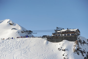 Restaurant at a hill of a ski resort in winter with snow and blue sky