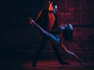 Professional dancers perform an incendiary dance in a dark room with illumination
