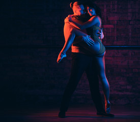 Professional dancers perform an incendiary dance in a dark room with illumination