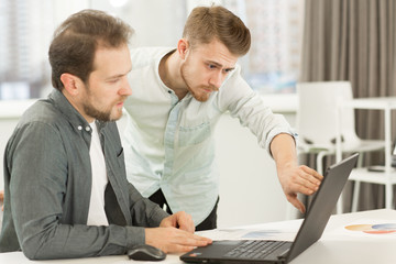 Fototapeta premium Two businessmen working at the office together