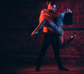 Professional dancers perform an incendiary dance in a dark room with illumination