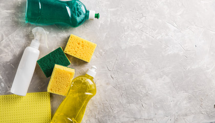 flat lay composition with cleaning supplies for dish washing and space for text on grey background