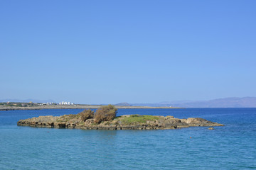 a small atoll surrounded by the blue sea