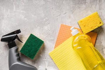 flat lay composition with cleaning supplies for dish washing and space for text on grey background