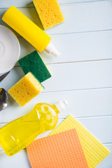 flat lay composition with cleaning supplies for dish washing and space for text on blue background