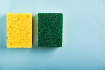 Yellow kitchen sponge isolated on blue background