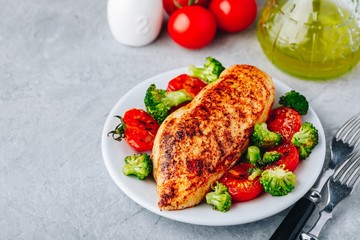 Healthy lunch bowl with roasted chicken, grilled tomatoes and broccoli