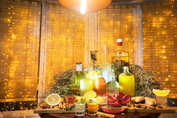 The range of alcoholic tinctures in the bar on the table near the window with blinds and a garland