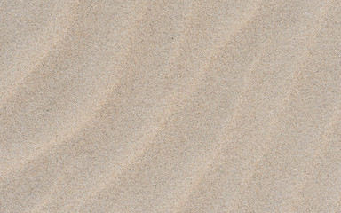 Fototapeta na wymiar Ripple on the sand. Nature cream background