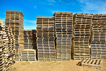 piles of european pallets made in wood ready to be used transporting products or goods on them from a place to other by truck, plane or ship.