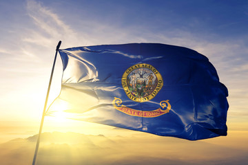 Idaho state of United States flag waving on the top sunrise mist fog