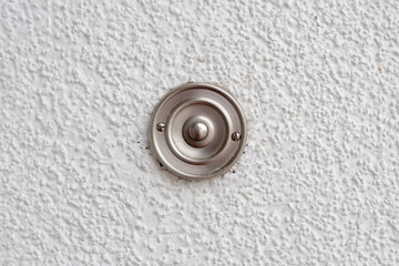 Stainless steel doorbell on a white wall
