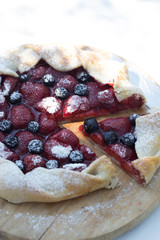 Sweet fruit open pies with strawberries and blueberries. Homemade baked galettes with strawberries and blueberries.
