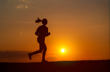 Fototapeta na wymiar Silhouette of the running girl at sunrise.