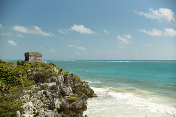 The temple of Tulum stands out against the carribean sea.