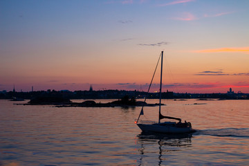 Boat in the evening twilight in the waters of the Gulf of Finland off the coast of Helsinki in Finland on a summer evening.