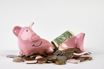 Broken piggy bank with coins money isolated on white background, close-up