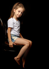 Fototapeta na wymiar Little girl on a black background