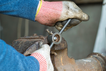 Worker cuts a thread with a die