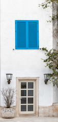 A window with blue shutters and door