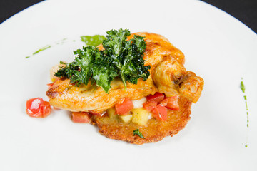Chicken served with potato pancake some vegetables decorated with pea mash