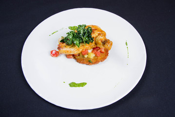 Chicken served with potato pancake some vegetables decorated with pea mash