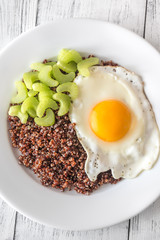 Portion of red quinoa with fried egg and celery