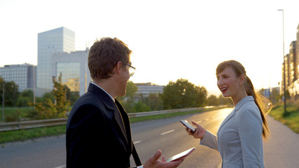 CLOSE UP: Carefree businessman and woman smile after bumping into each other.