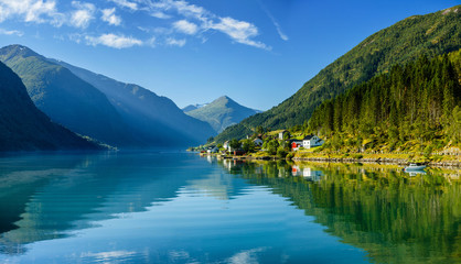 Beautiful fishing houses on fjord. Beautiful nature with blue sky, reflection in water and fishing house. Norway