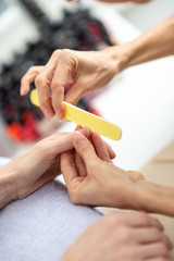 Closeup view of manicurist making manicure