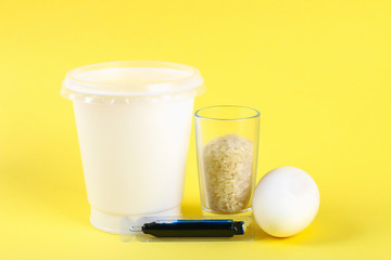 Diy Easter egg painted with colored rice on a yellow background. The decor of eggs for Easter