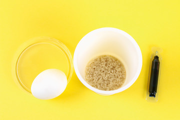 Diy Easter egg painted with colored rice on a yellow background. The decor of eggs for Easter