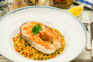 Grilled salmon steak. Salmon steak with lentils on rustic background 