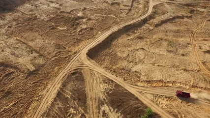 Aerial view of the large red truck moving on a sandy track in desert. Desert trip.