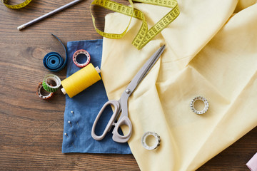 Overview or background of tailoring stuff - textile, scissors, spool, measuring tape, cellotape and...