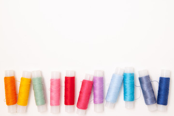 Tailor work place with Multicolored thread coils. Sewing as hobby. White background top view. space for text. flat lay. Minimalism