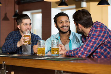 Men time. Shot of three male friends having drinks at the local bar