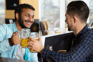 To my wingman. Portrait of a two men having drinks at the pub smiling happily