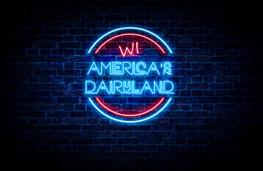 A sign showing Wisconsin state slogan, in blue and red neon light on a brick wall background and wires on the side.