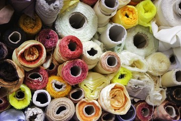 Fototapeta na wymiar rolls of colored fabrics in the fabric store