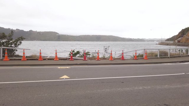 Wide pan over car crash site, fence broken from collision. Wellington, New Zealand