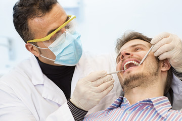 Mature male dentist working with his patient