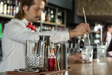 True professionalism. Vintage and stylish bartender preparing glasses for drinks